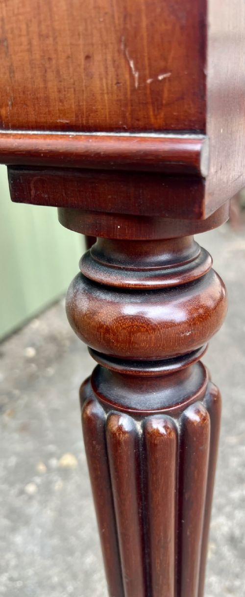 A nineteenth-century mahogany side table with a low gallery back, two frieze drawers, and turned reeded legs on brass castors. View XI