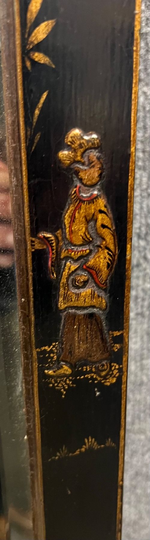 A tall, narrow black lacquered hall mirror decorated with gilded Chinoiserie pagodas and figures, featuring an arched top and front cabriole legs. View V