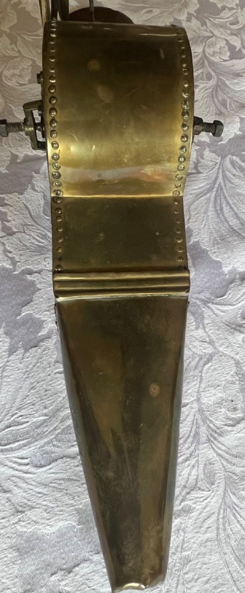 An antique mechanical rotary fireplace bellows featuring a mahogany wooden base, a brass spoked wheel with a hand crank, a driving band, and a brass casing leading to a tapered nozzle. View III