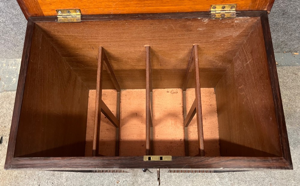 A low rectangular antique rosewood cellarette cabinet with twin panelled doors framed by beaded moulding, resting on turned feet with brass castors. View III