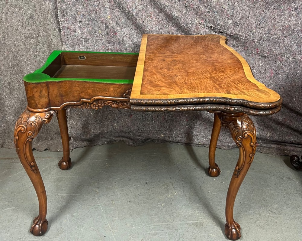 A burr walnut card table featuring a serpentine top with crossbanded borders, an ornate shell-carved apron, and cabriole legs ending in ball and claw feet. View VIII