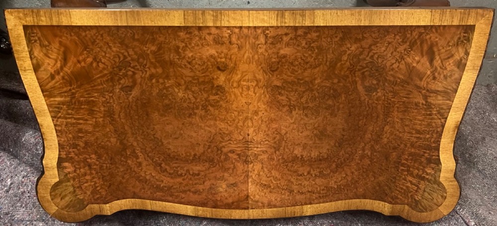 A burr walnut card table featuring a serpentine top with crossbanded borders, an ornate shell-carved apron, and cabriole legs ending in ball and claw feet. View IX
