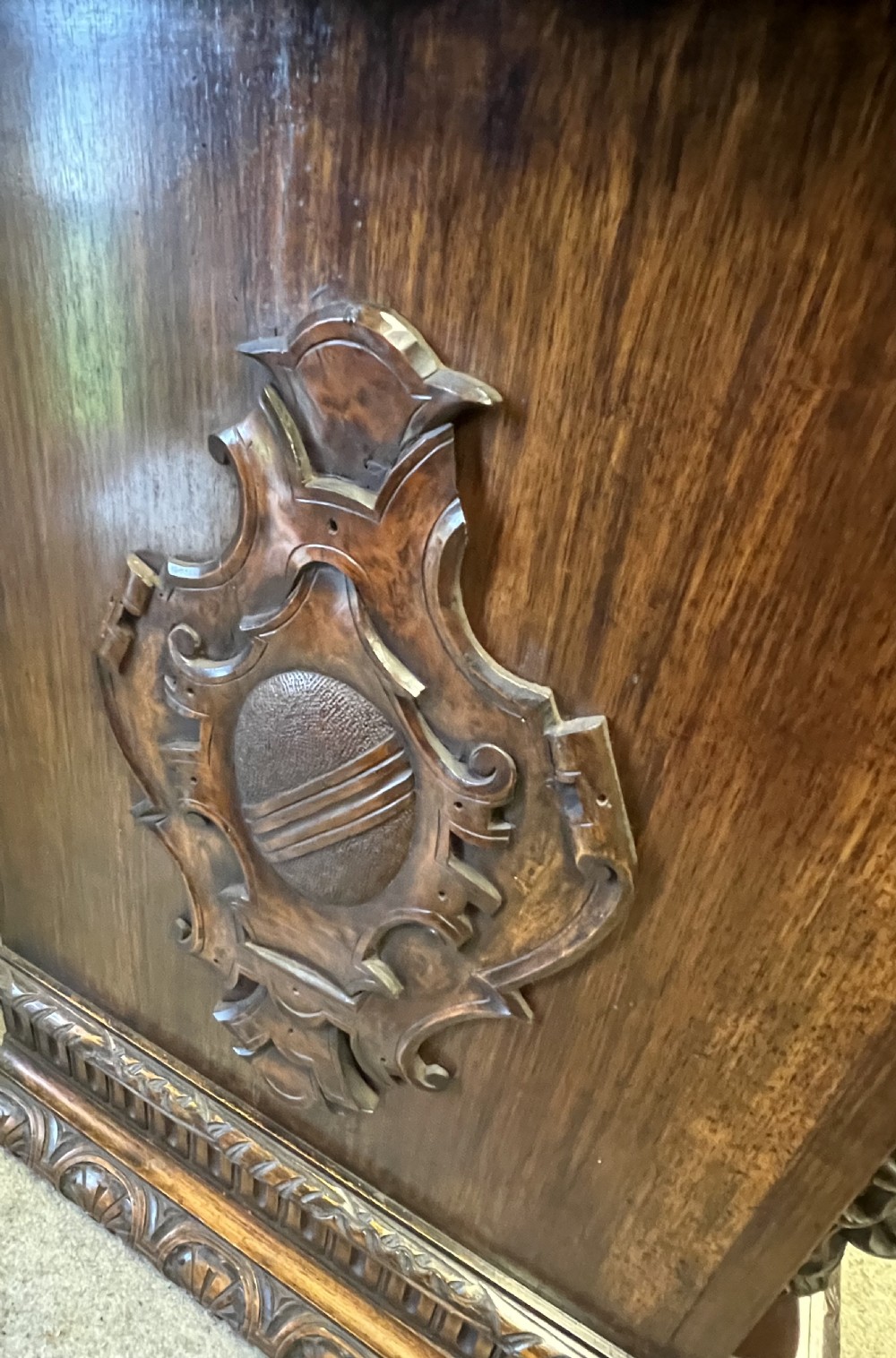 A heavily carved dark walnut cabinet featuring figurative reliefs, caryatid supports, mask motifs, and an architectural cresting. View XVIII