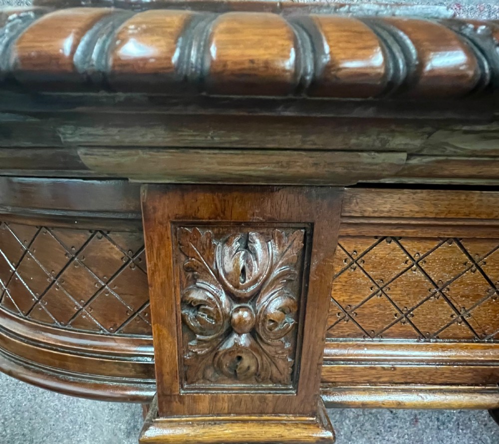 An antique dark brown carved wood console table featuring a shell motif central frieze and detailed scrolled legs. View V