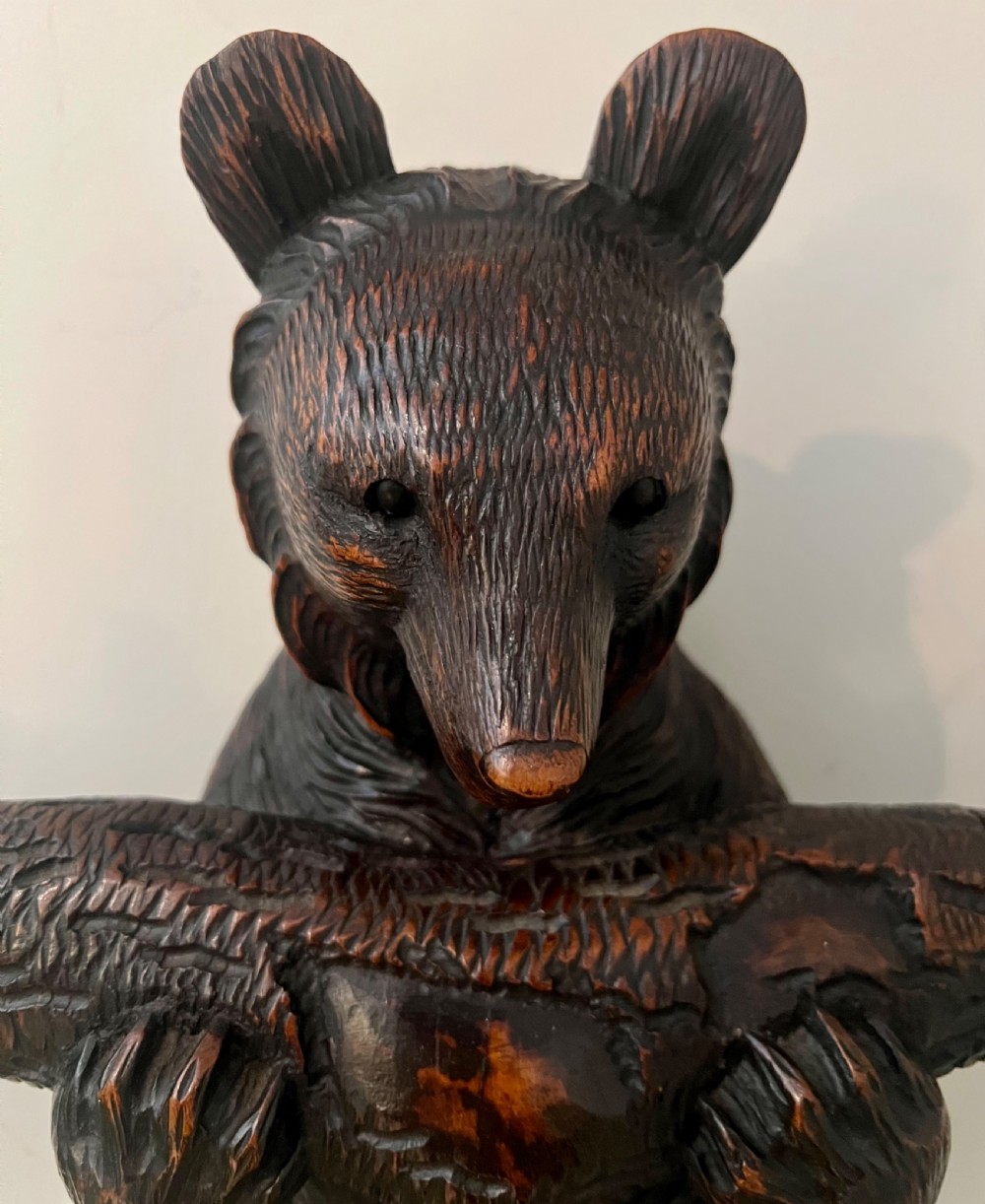 A tall dark wood hand-carved Black Forest hall stand featuring climbing bear figures, branch-form coat pegs, and an integrated umbrella ring with a drip pan base. View II