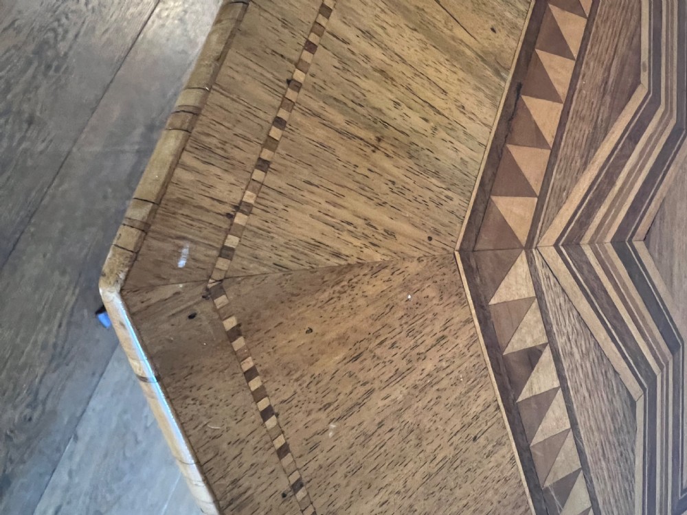 An octagonal wooden occasional table featuring geometric marquetry star patterns on the top and a turned pedestal column supported by three inlaid legs. View IV