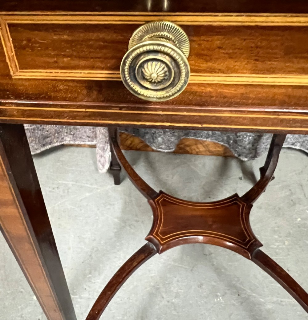 An Edwardian mahogany Pembroke side table featuring satinwood crossbanding, drop leaves, a single drawer with twin brass handles, square tapered legs, and a curved lower X-stretcher. View VI