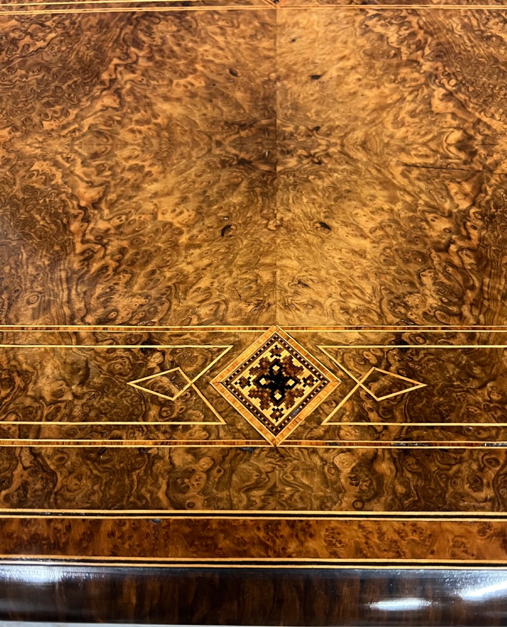 A Victorian burr walnut card table featuring geometric Tunbridge Ware inlay, turned twin-column supports, and a stretcher base on castors. View IV