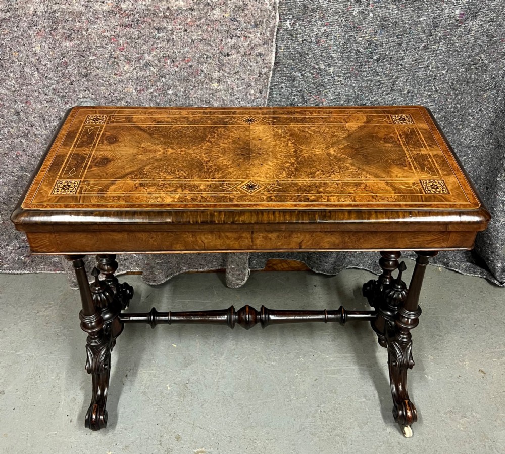 A Victorian burr walnut card table featuring geometric Tunbridge Ware inlay, turned twin-column supports, and a stretcher base on castors. View XI