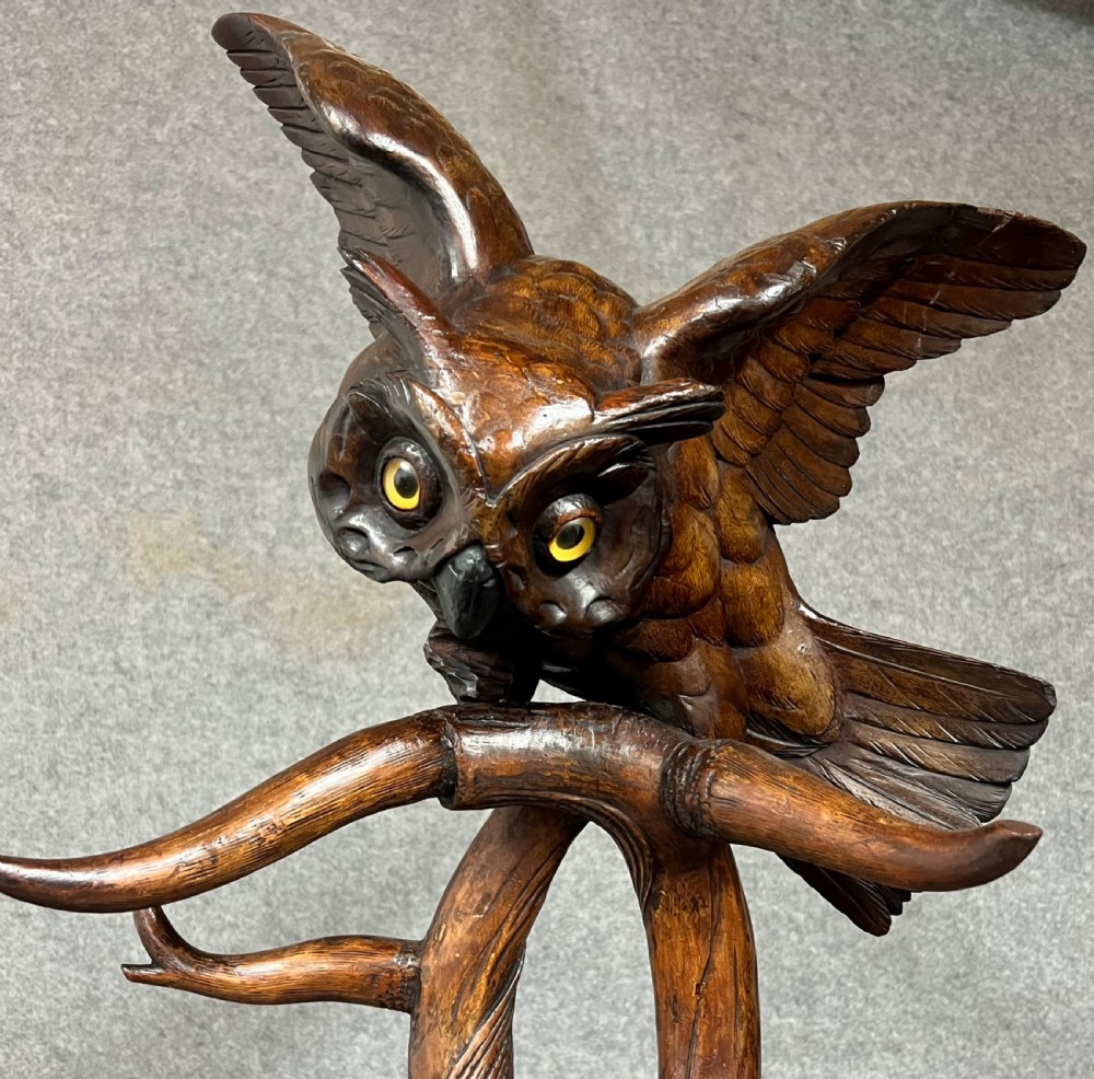 A dark wood hand-carved Black Forest hall stand featuring a fox at the base looking up towards an owl perched atop branch-form hooks. View II