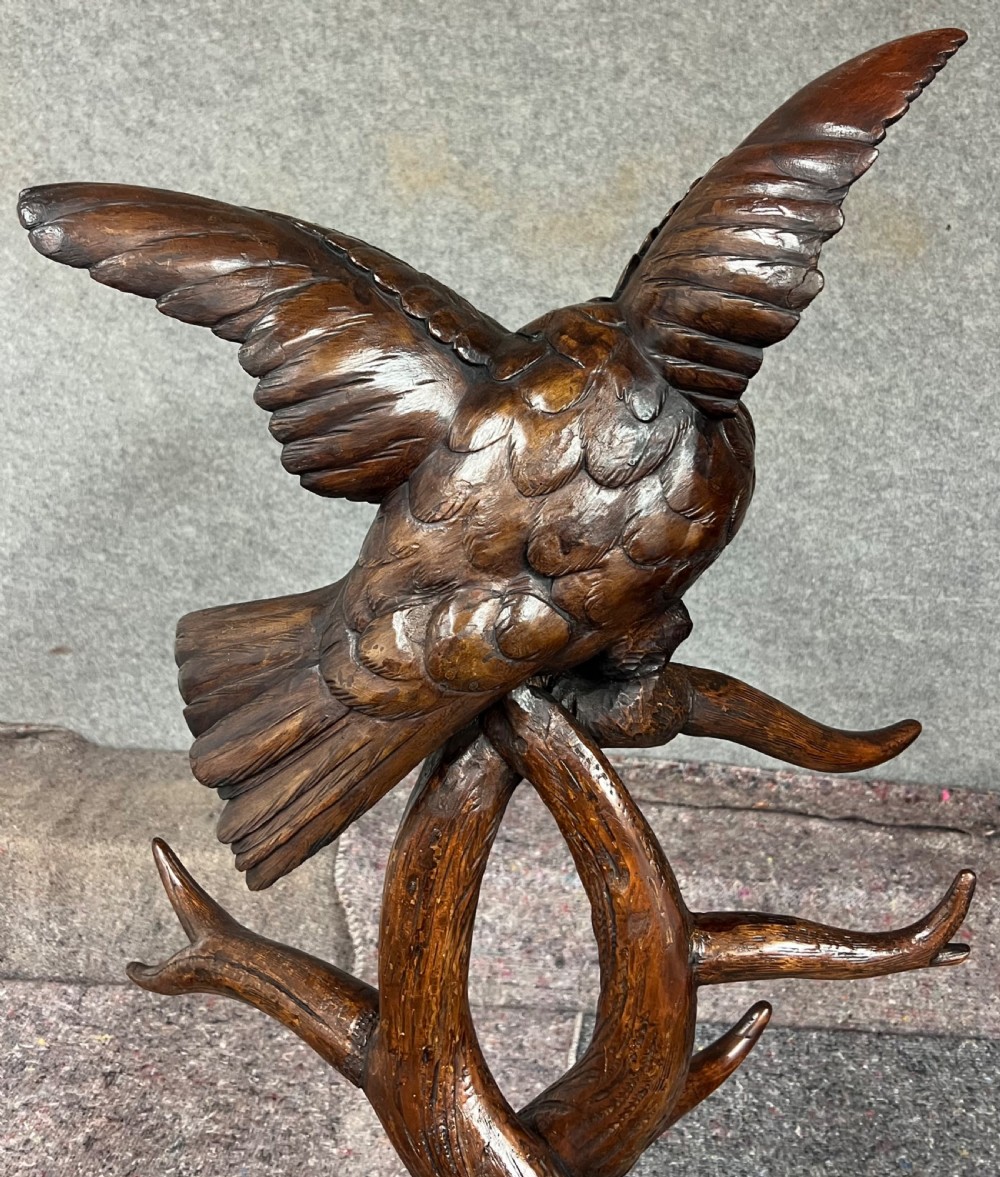 A dark wood hand-carved Black Forest hall stand featuring a fox at the base looking up towards an owl perched atop branch-form hooks. View V