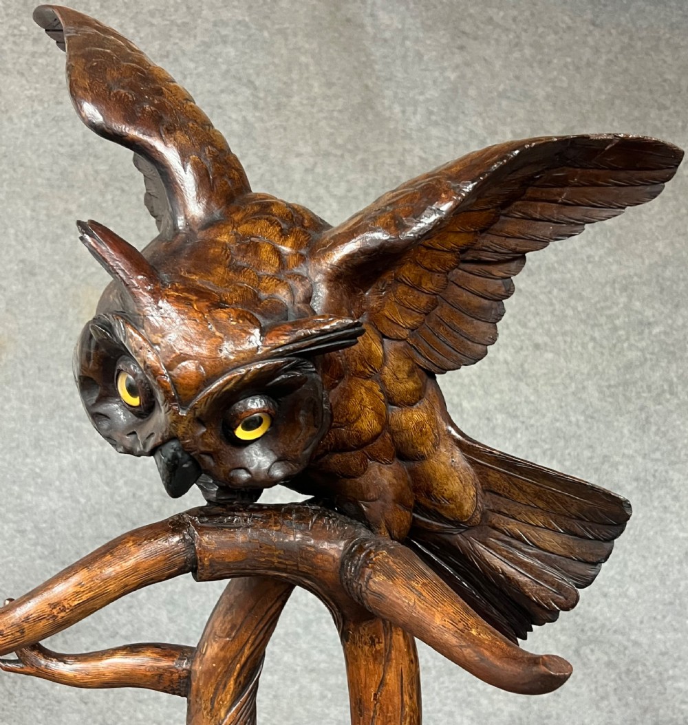 A dark wood hand-carved Black Forest hall stand featuring a fox at the base looking up towards an owl perched atop branch-form hooks. View VII
