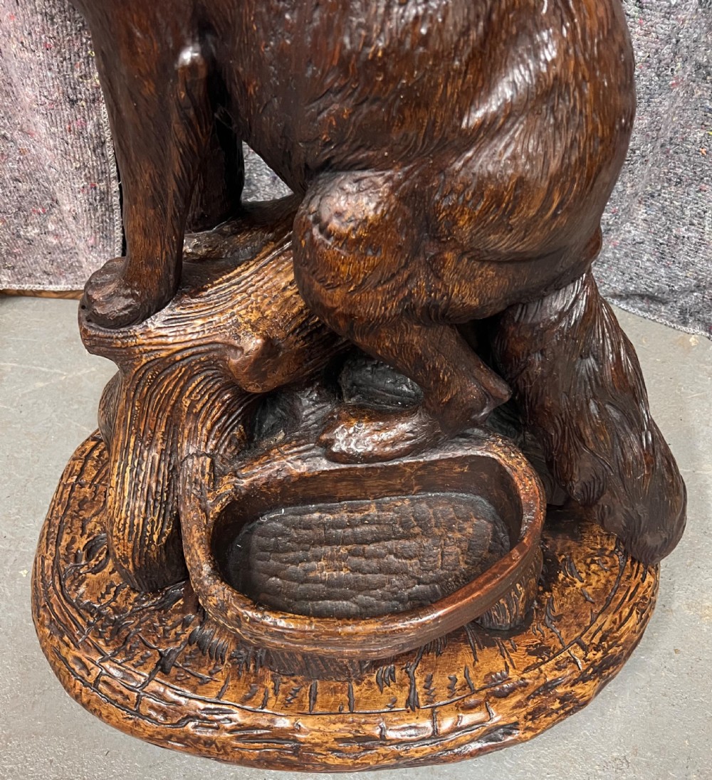 A dark wood hand-carved Black Forest hall stand featuring a fox at the base looking up towards an owl perched atop branch-form hooks. View IX