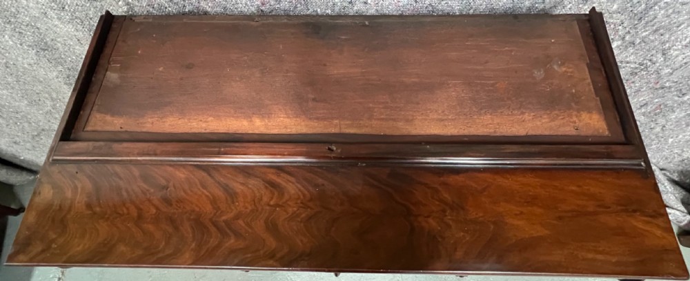 An antique flame mahogany chiffonier bookcase featuring a glazed two-door top cabinet above a lower base with two arched panelled cupboard doors. View VI