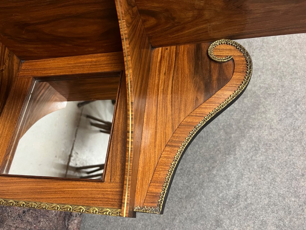 A Regency style rosewood breakfront open bookcase with tiered shelving filled with books, brass star handles, mirrored side compartments, and turned legs. View XV