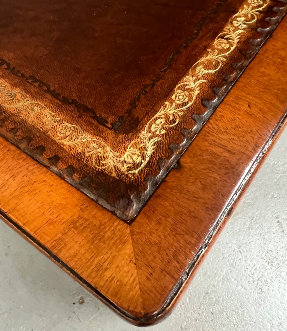 A George III mahogany partners desk featuring a leather writing surface, multiple drawers with turned brass handles, and a twin-pedestal design. View VI