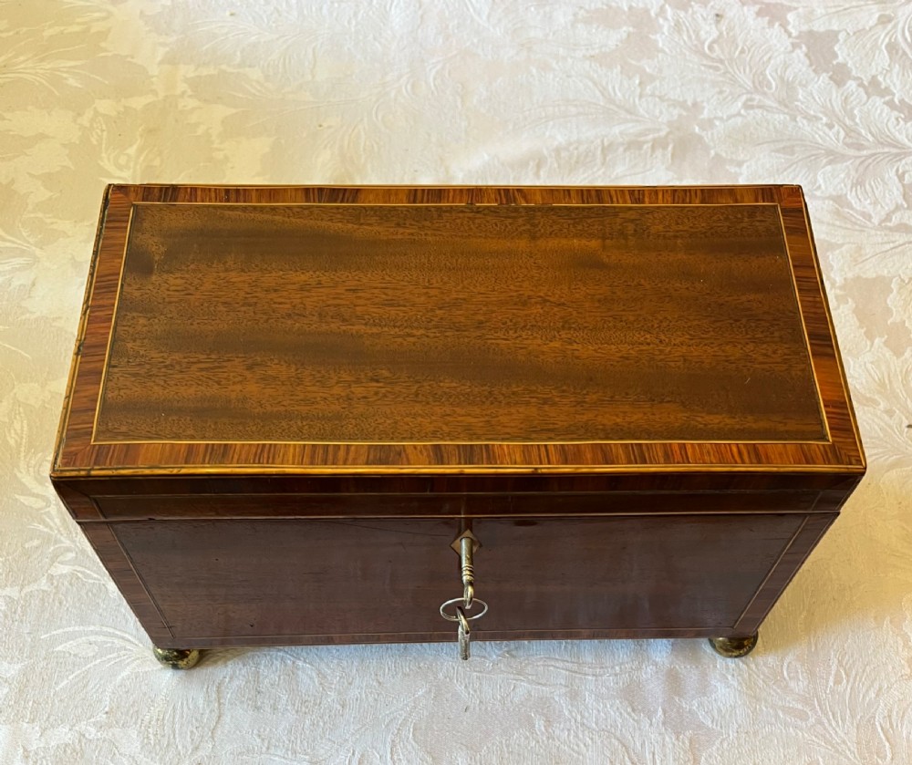 An open Georgian mahogany tea caddy displaying twin inlaid lidded compartments and a central glass mixing bowl. View II