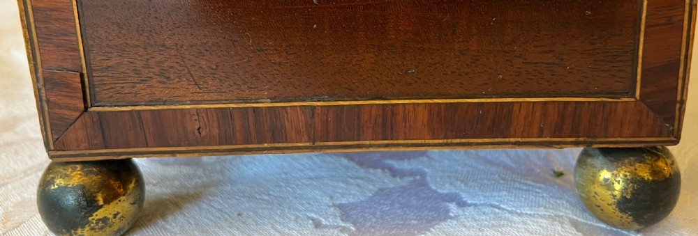 An open Georgian mahogany tea caddy displaying twin inlaid lidded compartments and a central glass mixing bowl. View V