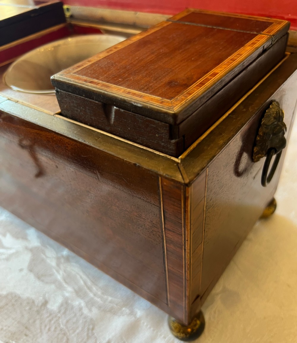 An open Georgian mahogany tea caddy displaying twin inlaid lidded compartments and a central glass mixing bowl. View VI