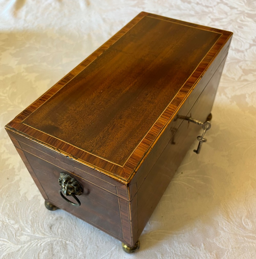 An open Georgian mahogany tea caddy displaying twin inlaid lidded compartments and a central glass mixing bowl. View VII