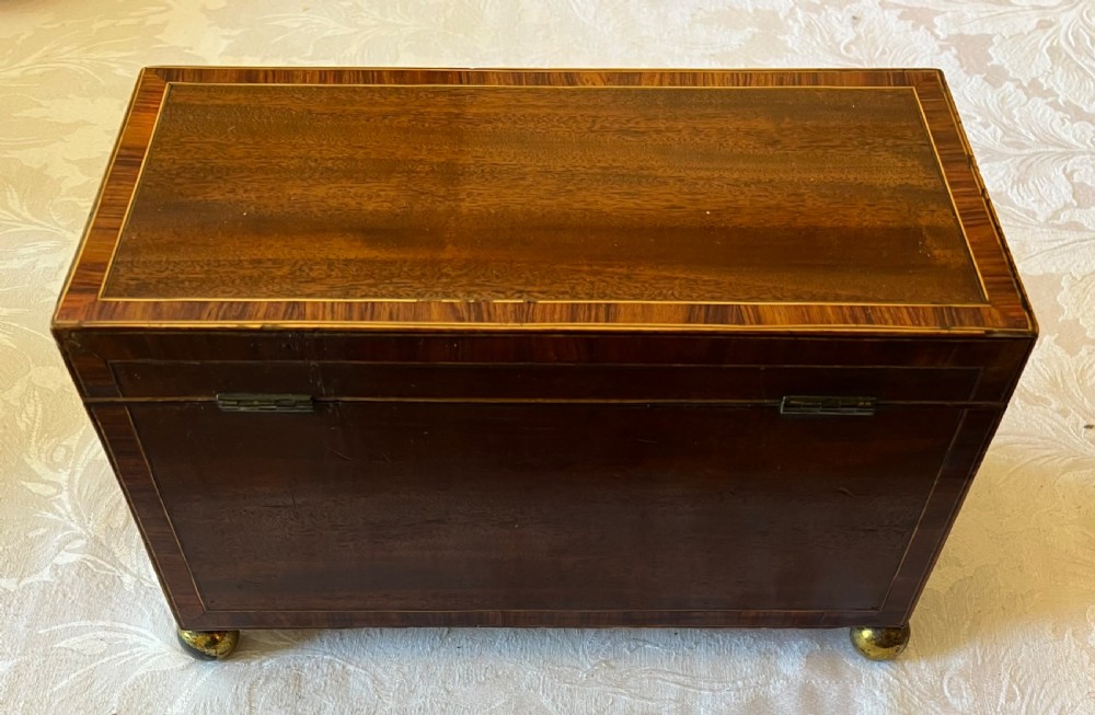 An open Georgian mahogany tea caddy displaying twin inlaid lidded compartments and a central glass mixing bowl. View VIII