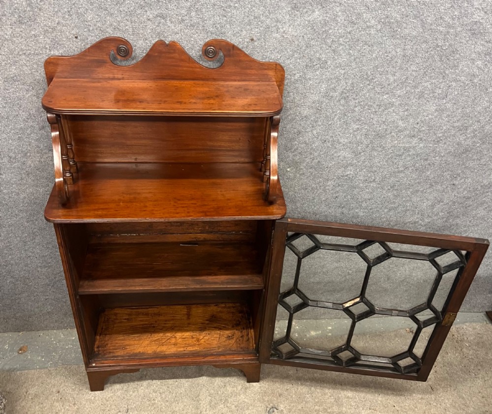 A small Regency mahogany cabinet featuring an upper scroll gallery, turned spindle supports, and a single glazed door with geometric timber tracery. View VIII