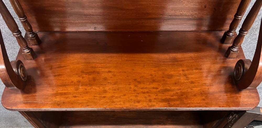 A small Regency mahogany cabinet featuring an upper scroll gallery, turned spindle supports, and a single glazed door with geometric timber tracery. View IX