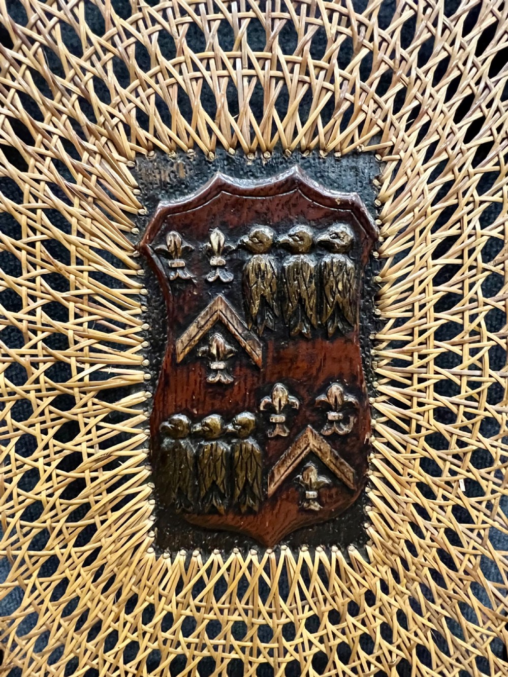 A carved dark wood Carolean style triple chair-back settee with barley twist turnings, crest carving, and woven cane seat and back panels. View II