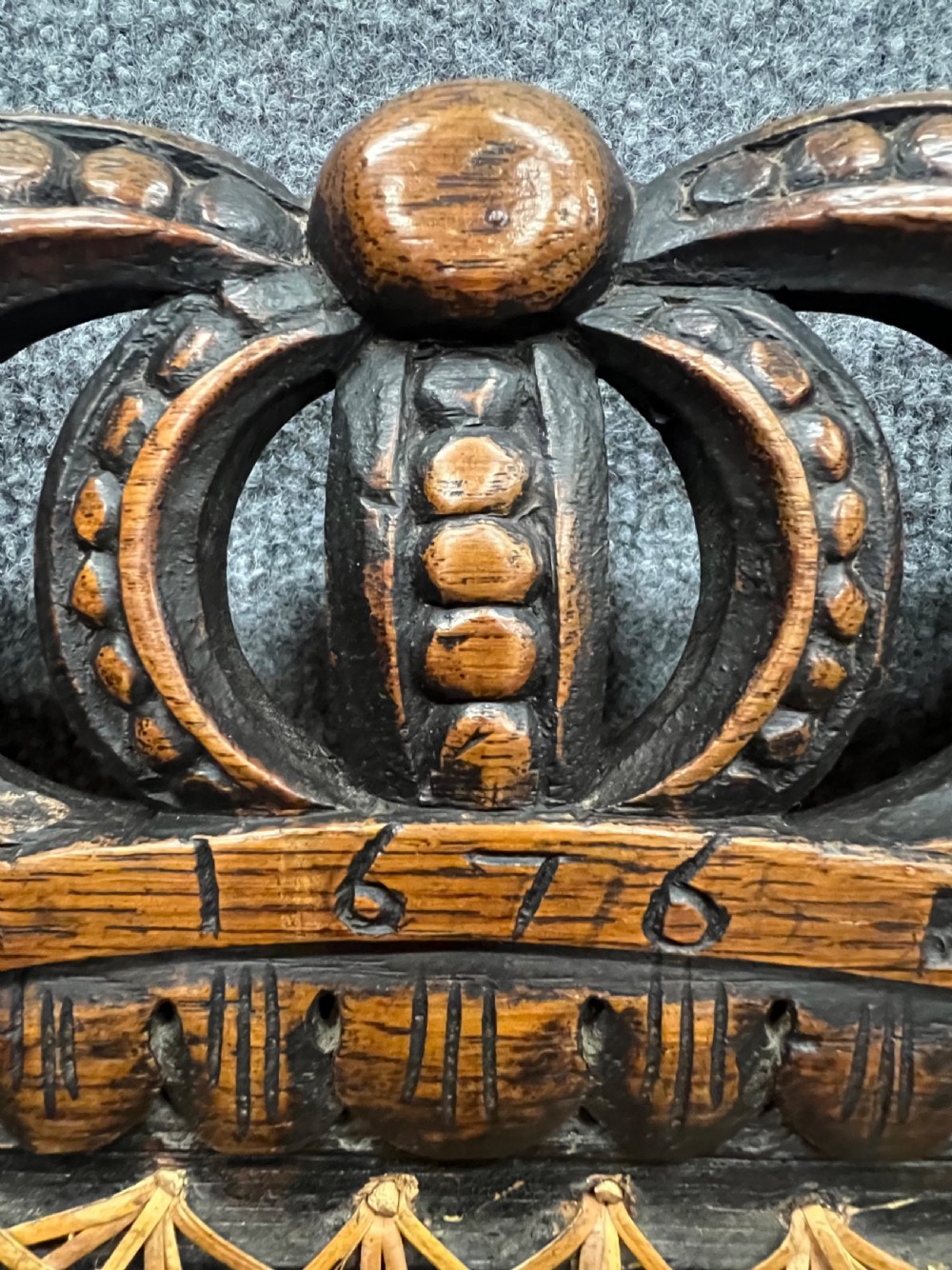 A carved dark wood Carolean style triple chair-back settee with barley twist turnings, crest carving, and woven cane seat and back panels. View III