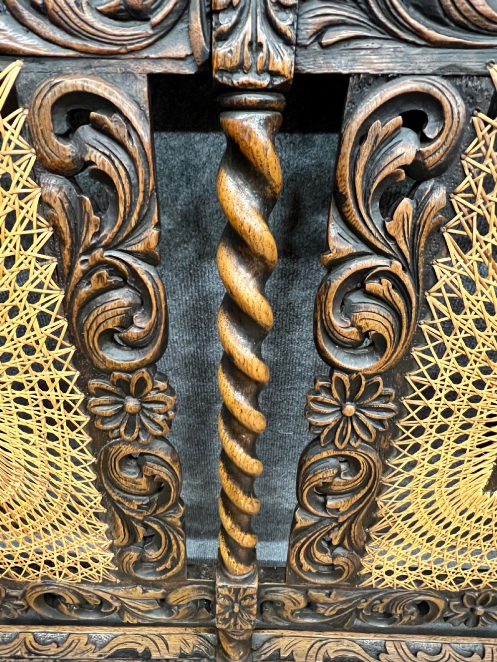 A carved dark wood Carolean style triple chair-back settee with barley twist turnings, crest carving, and woven cane seat and back panels. View VI