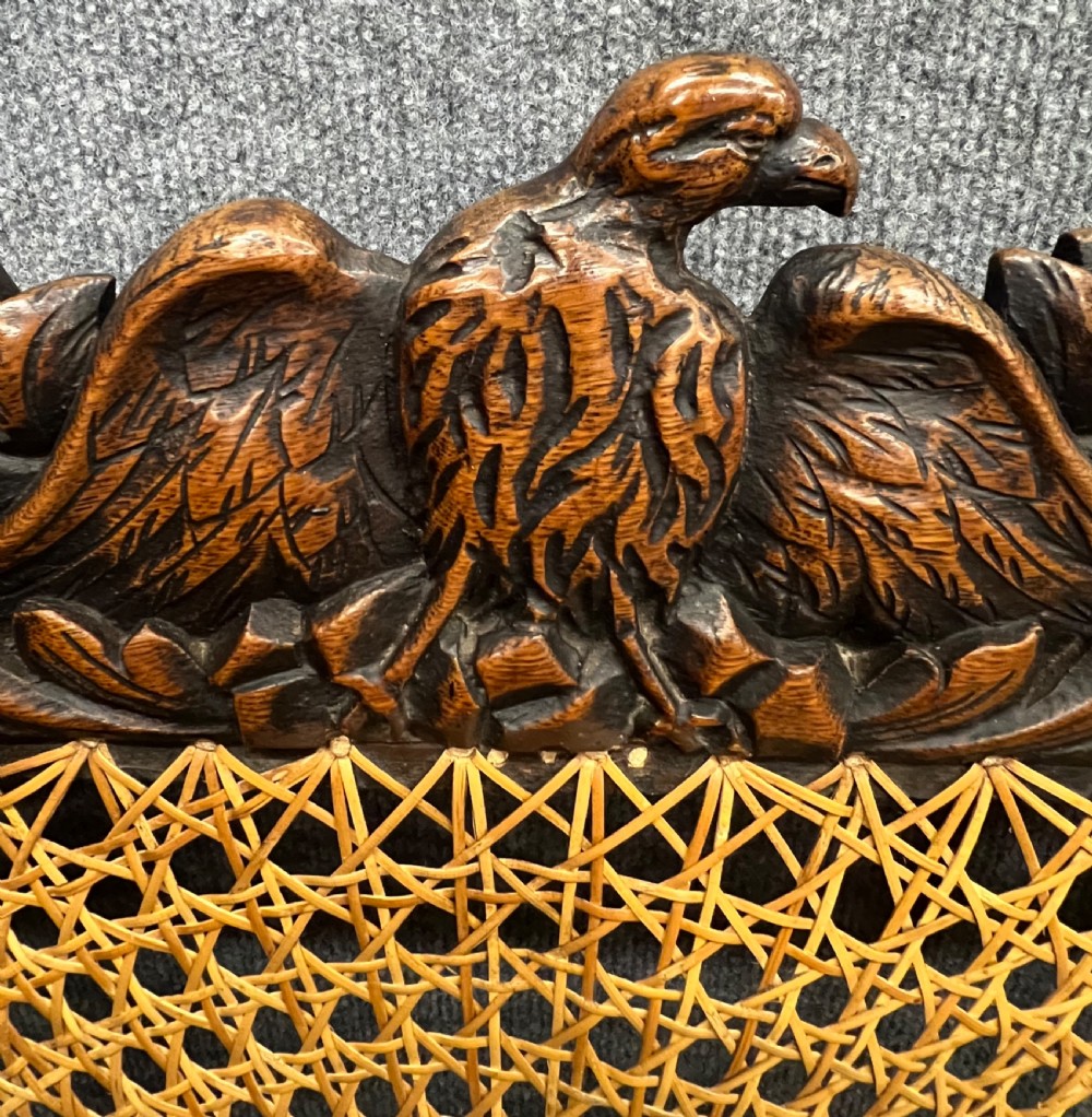A carved dark wood Carolean style triple chair-back settee with barley twist turnings, crest carving, and woven cane seat and back panels. View VII