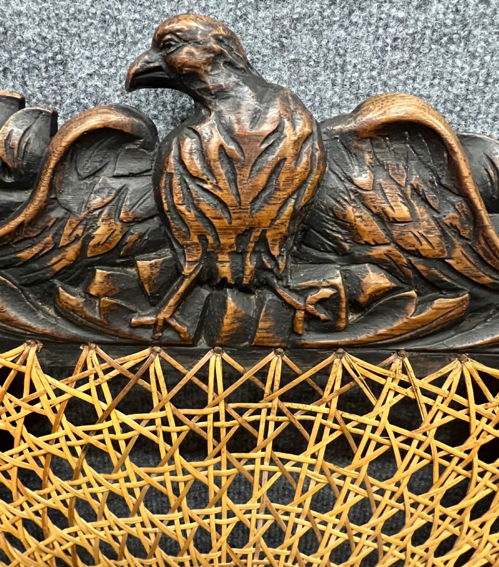 A carved dark wood Carolean style triple chair-back settee with barley twist turnings, crest carving, and woven cane seat and back panels. View IX