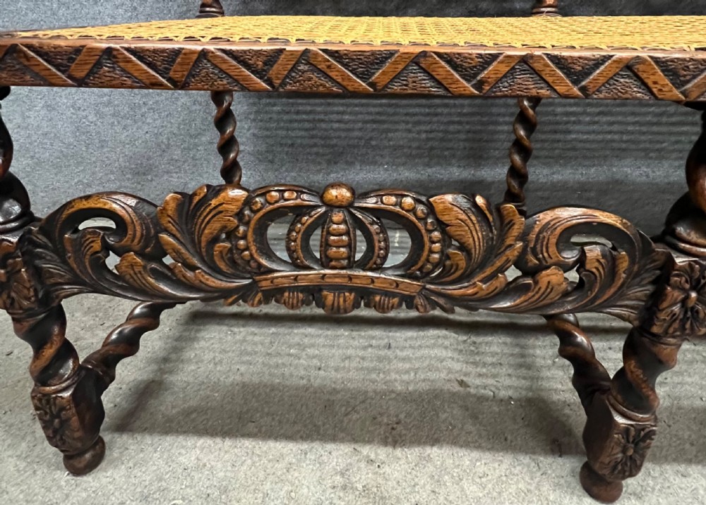 A carved dark wood Carolean style triple chair-back settee with barley twist turnings, crest carving, and woven cane seat and back panels. View XI