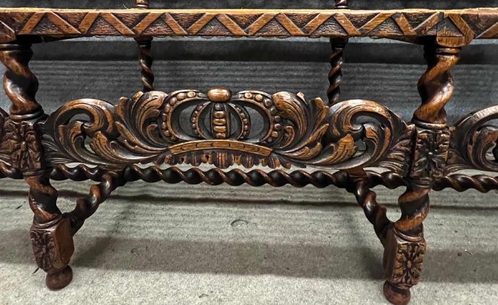 A carved dark wood Carolean style triple chair-back settee with barley twist turnings, crest carving, and woven cane seat and back panels. View XII