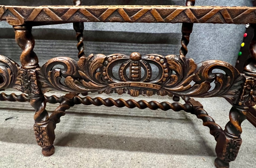 A carved dark wood Carolean style triple chair-back settee with barley twist turnings, crest carving, and woven cane seat and back panels. View XIII