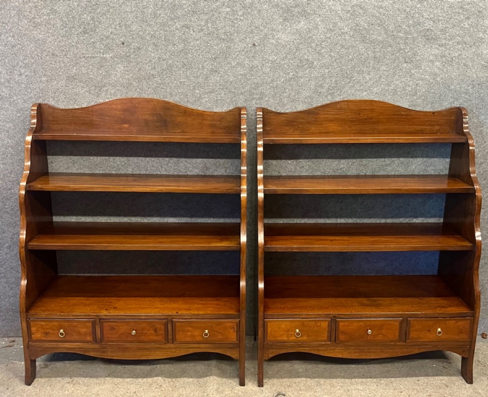 A pair of rich brown mahogany open waterfall bookcases featuring graduated shelves, serpentine side profiles, and three small drawers along the base. View II