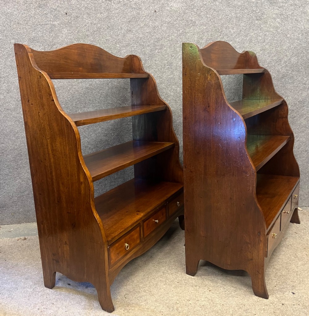 A pair of rich brown mahogany open waterfall bookcases featuring graduated shelves, serpentine side profiles, and three small drawers along the base. View III