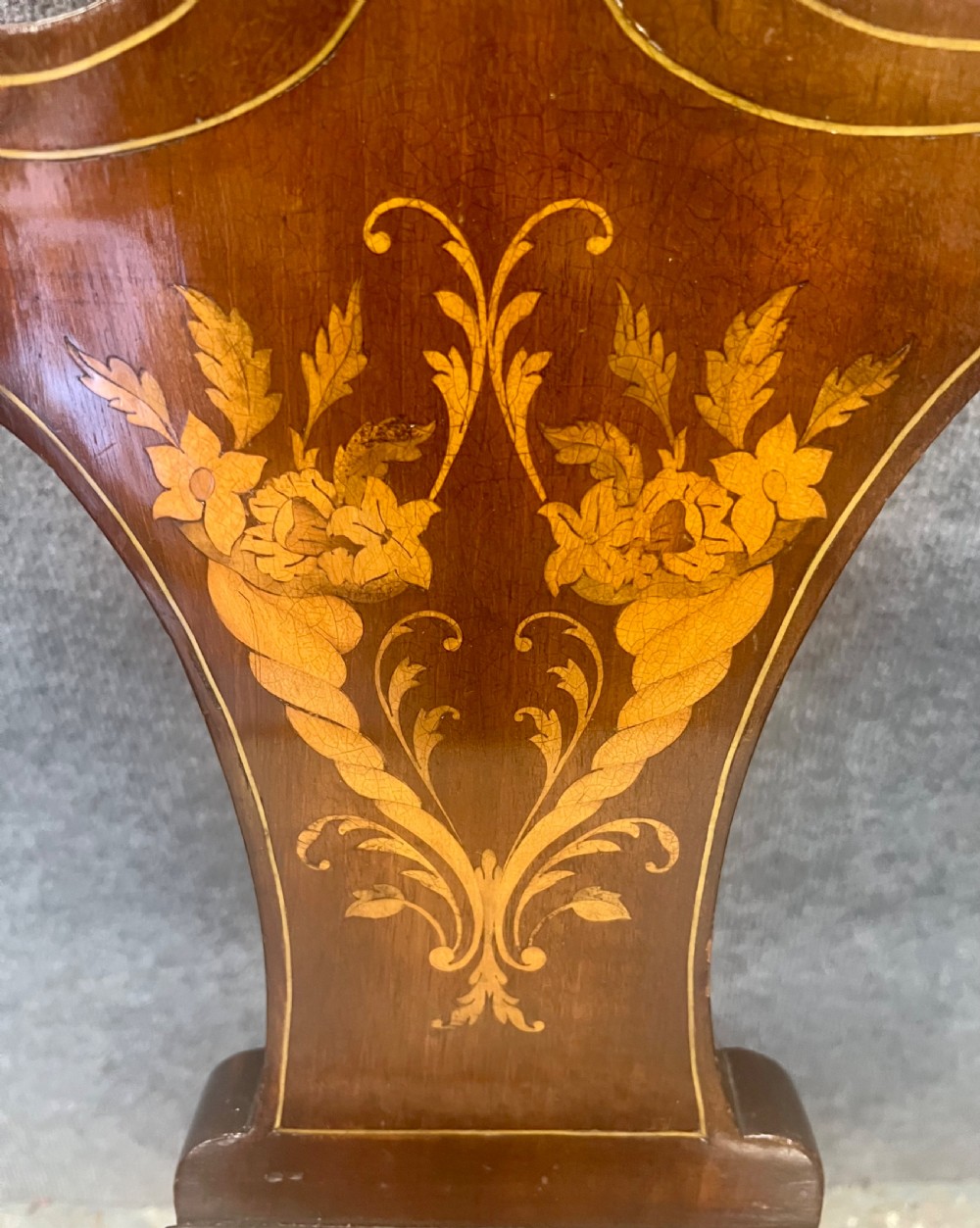 An Art Nouveau mahogany armchair featuring a carved pierced shell backrest, floral marquetry inlay, shaped armrests, and an upholstered seat pad. View III