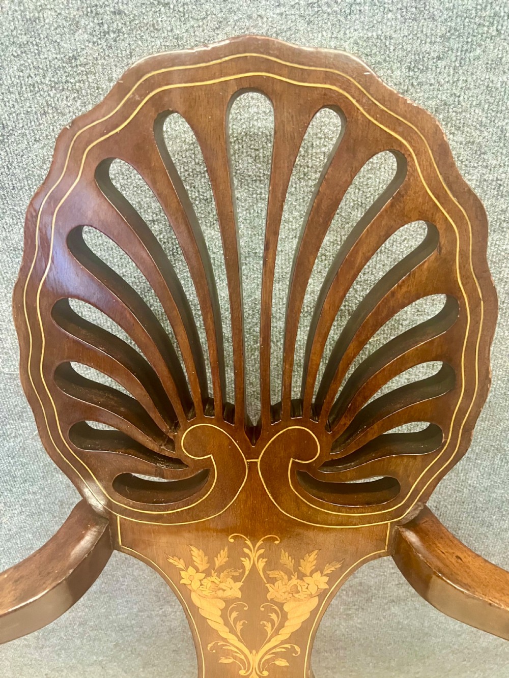 An Art Nouveau mahogany armchair featuring a carved pierced shell backrest, floral marquetry inlay, shaped armrests, and an upholstered seat pad. View IV