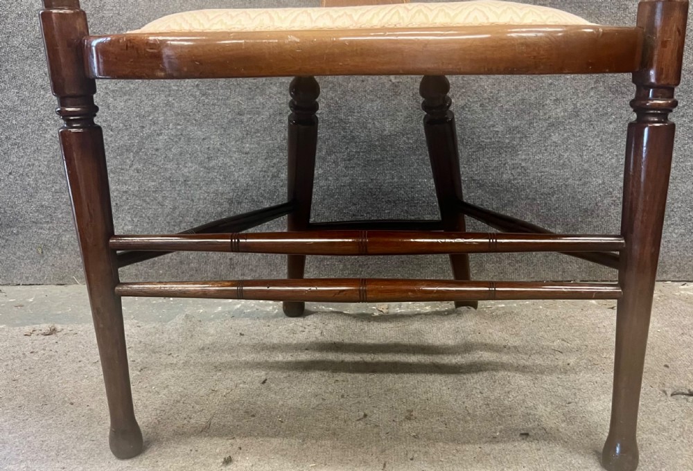 An Art Nouveau mahogany armchair featuring a carved pierced shell backrest, floral marquetry inlay, shaped armrests, and an upholstered seat pad. View VI