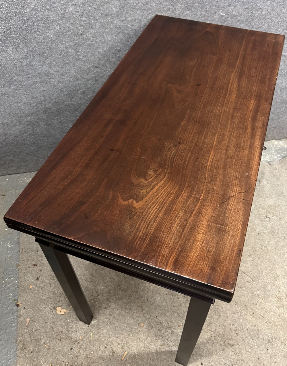 A Georgian dark mahogany fold-over table with straight square legs and a central brass swan-neck handle. View III