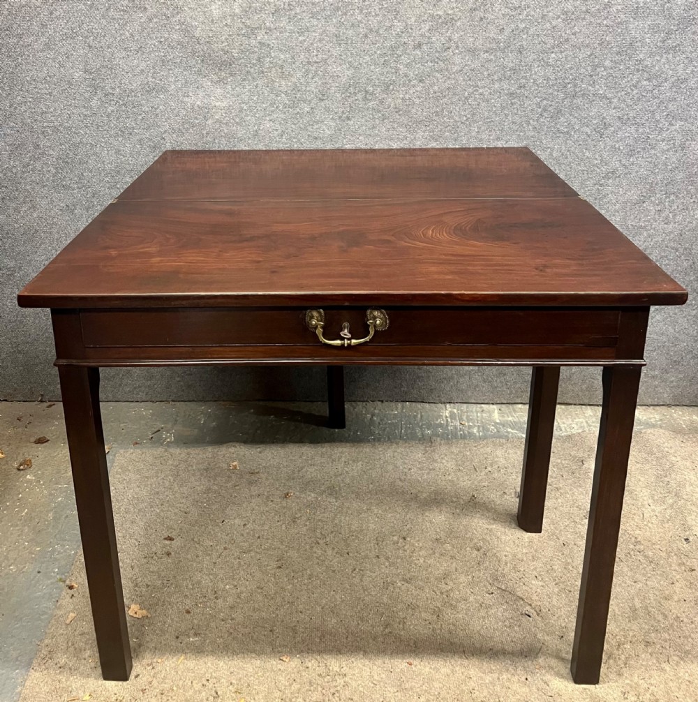 A Georgian dark mahogany fold-over table with straight square legs and a central brass swan-neck handle. View VI