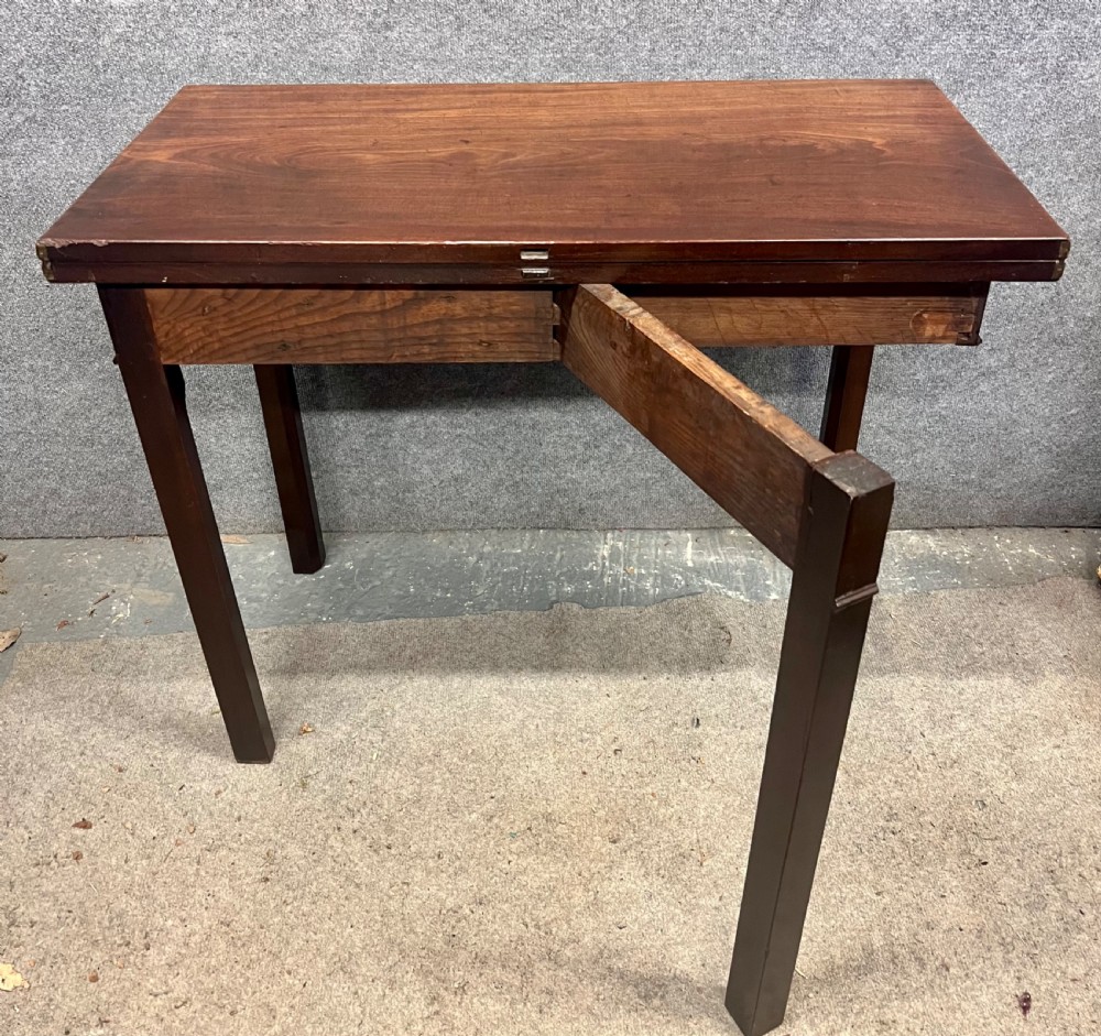 A Georgian dark mahogany fold-over table with straight square legs and a central brass swan-neck handle. View VII