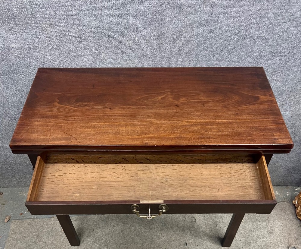A Georgian dark mahogany fold-over table with straight square legs and a central brass swan-neck handle. View IX