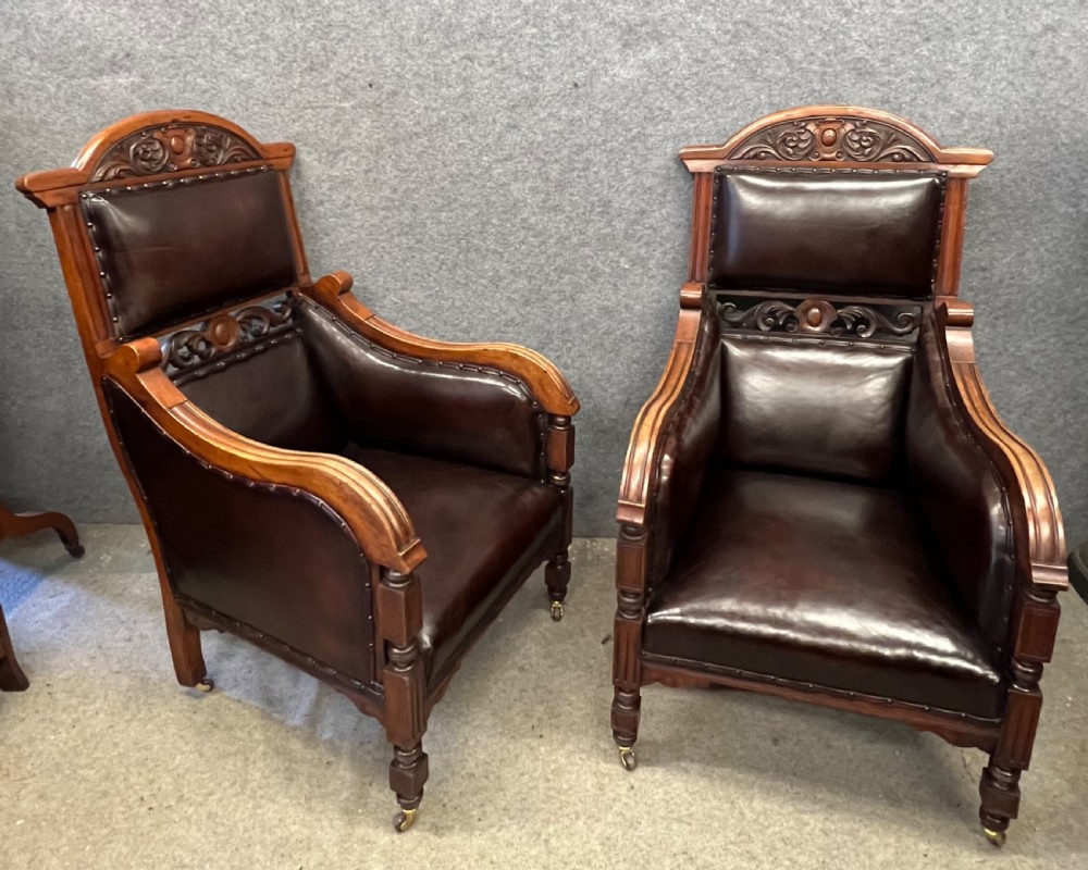 A pair of carved walnut high-back armchairs upholstered in dark brown leather with stud detailing and brass castors. View XI