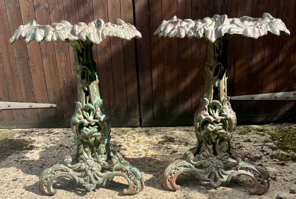 A pair of ornate cast iron pedestal tables with rococo scrollwork, tripod bases, and a verdigris green patinated finish. View II