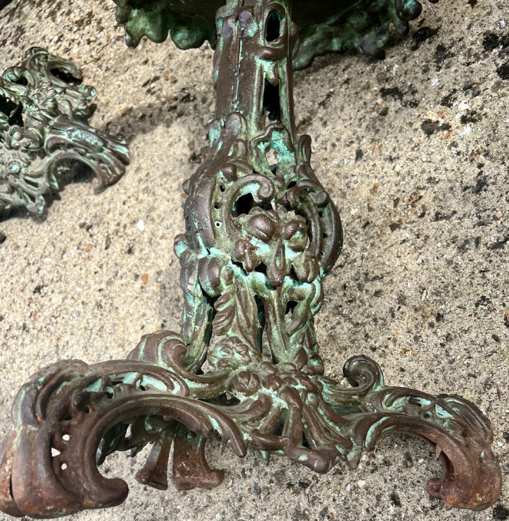 A pair of ornate cast iron pedestal tables with rococo scrollwork, tripod bases, and a verdigris green patinated finish. View V