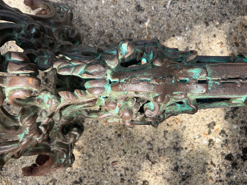 A pair of ornate cast iron pedestal tables with rococo scrollwork, tripod bases, and a verdigris green patinated finish. View VI