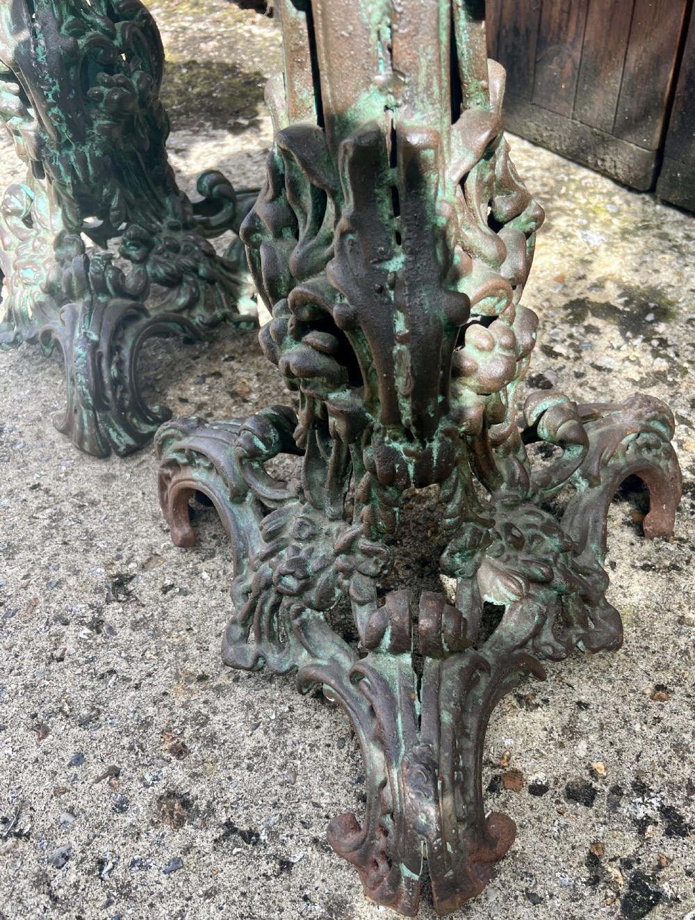 A pair of ornate cast iron pedestal tables with rococo scrollwork, tripod bases, and a verdigris green patinated finish. View XI