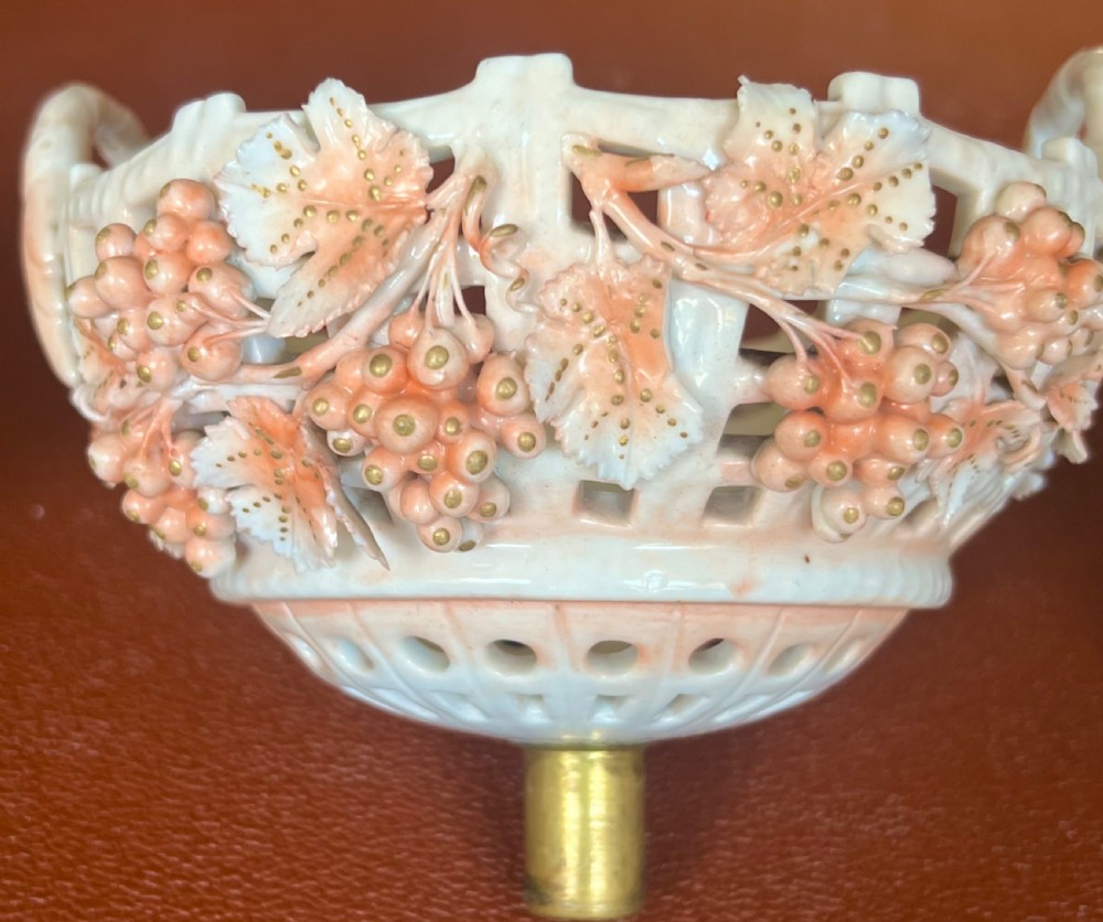 A pair of antique white and peach porcelain centrepiece comports with reticulated lattice baskets, floral applique, and moulded Rococo figures at the pedestals. View XI